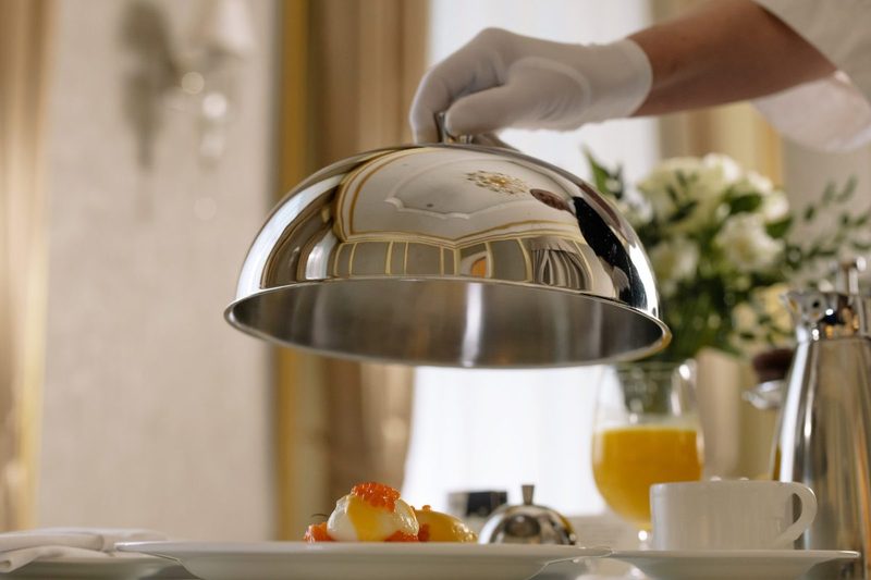 A room service tray being lifted up.