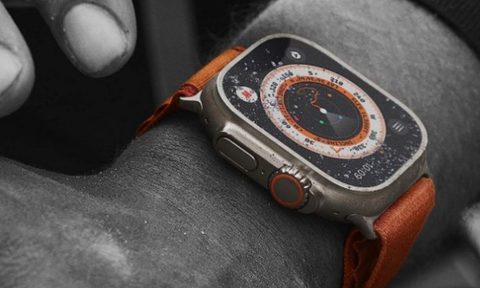 The Apple Watch Ultra covered in just a touch of sand on the arm of a man doing tough work.