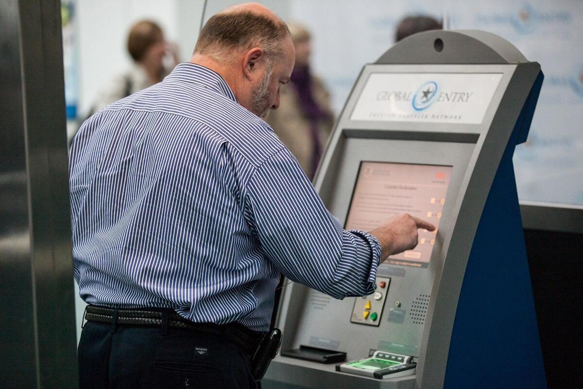 Air traveler entering information at a Global Entry airport kiosk