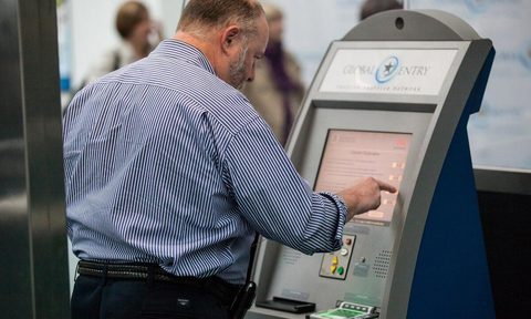 Air traveler entering information at a Global Entry airport kiosk