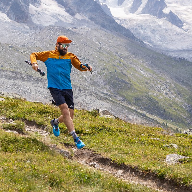 A Brooks trail running athlete runs down a mountain trail.