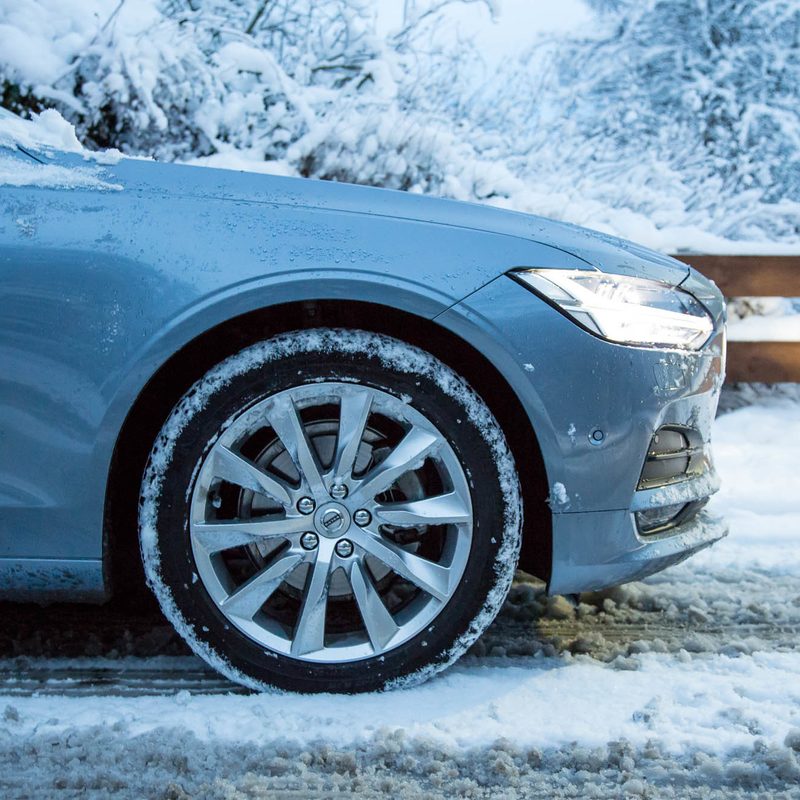 A car and its tires driving over snow.