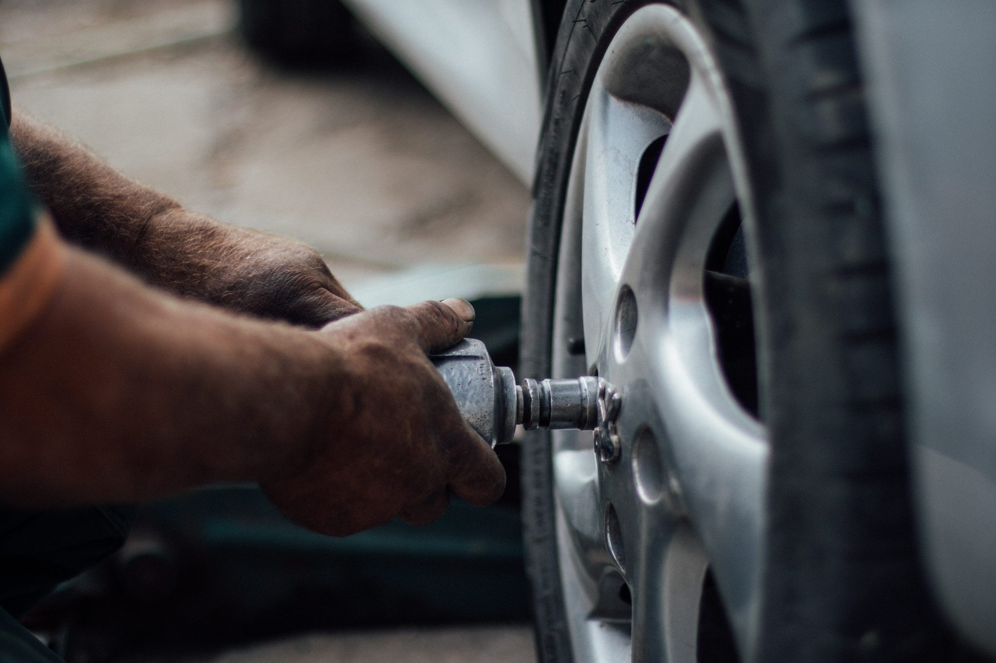 A tire technician changing worn tires.