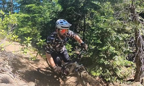 Going around a corner on a mountain bike with the Smith Forefront 2 helmet and Smith Wildcat sunglasses