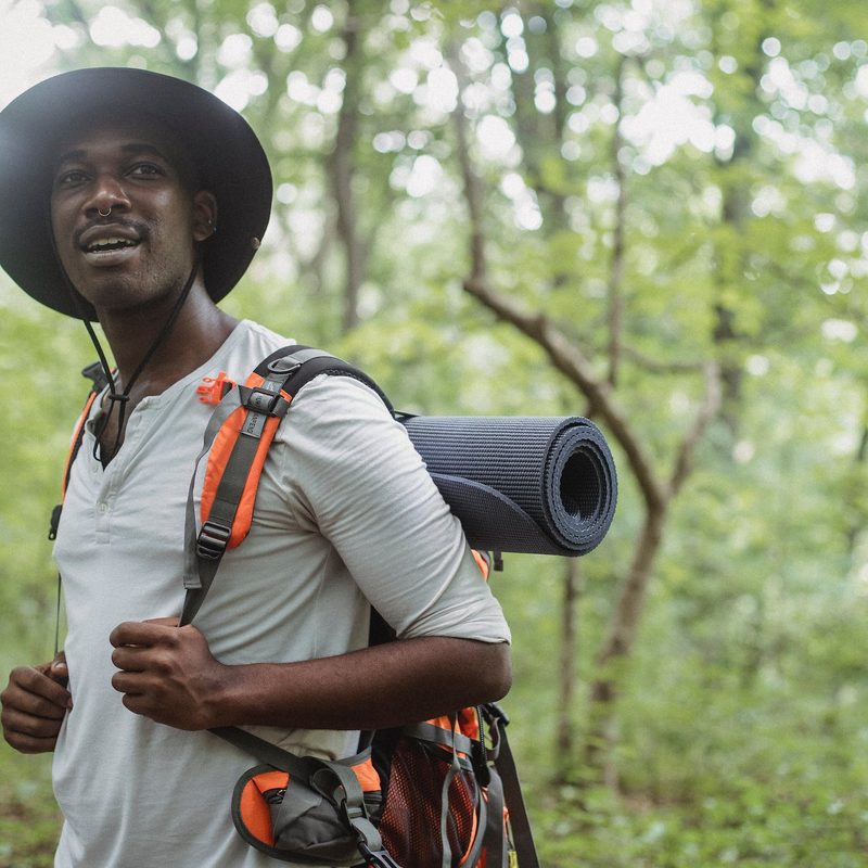 Man wearing hat and hiking outdoors