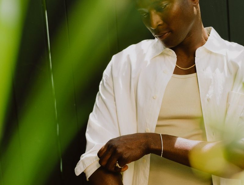 Man in white shirt with bracelet and necklace