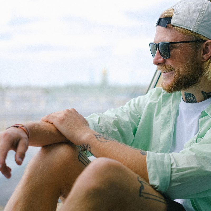 Seated man wearing sunglasses on sunny day