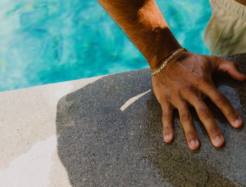 Man with bracelet getting out of pool