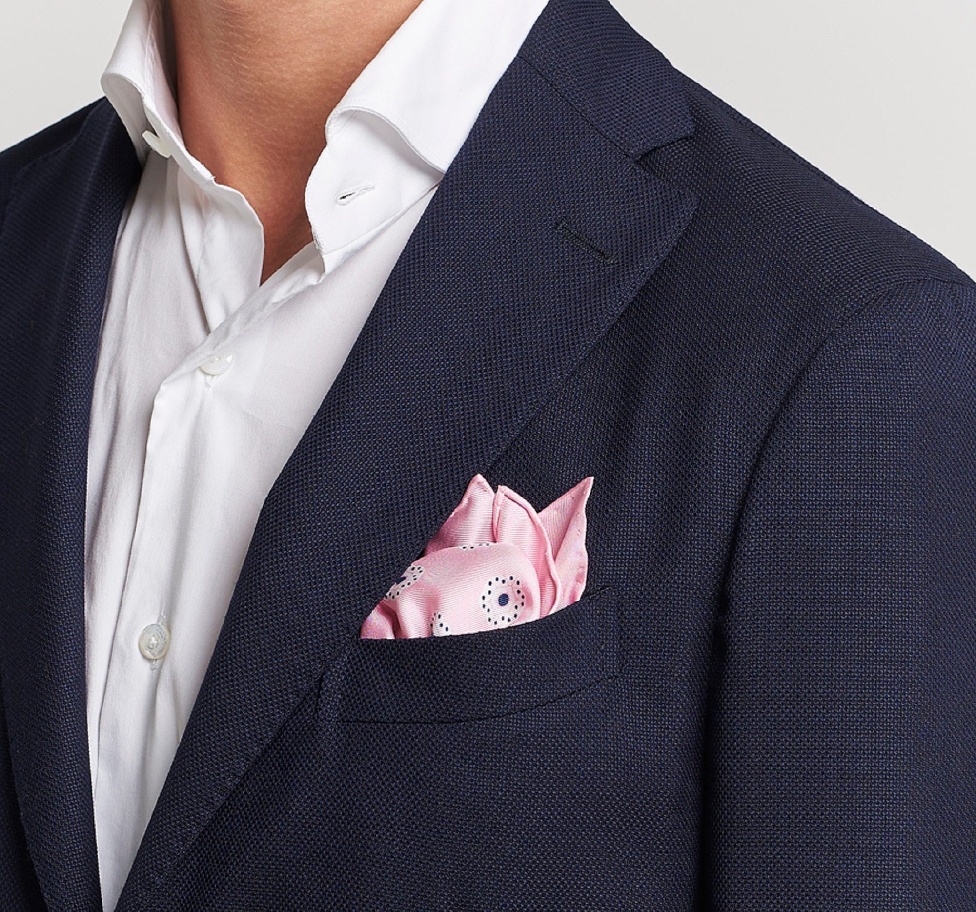 Man with blue blazer and pink pocket square close up