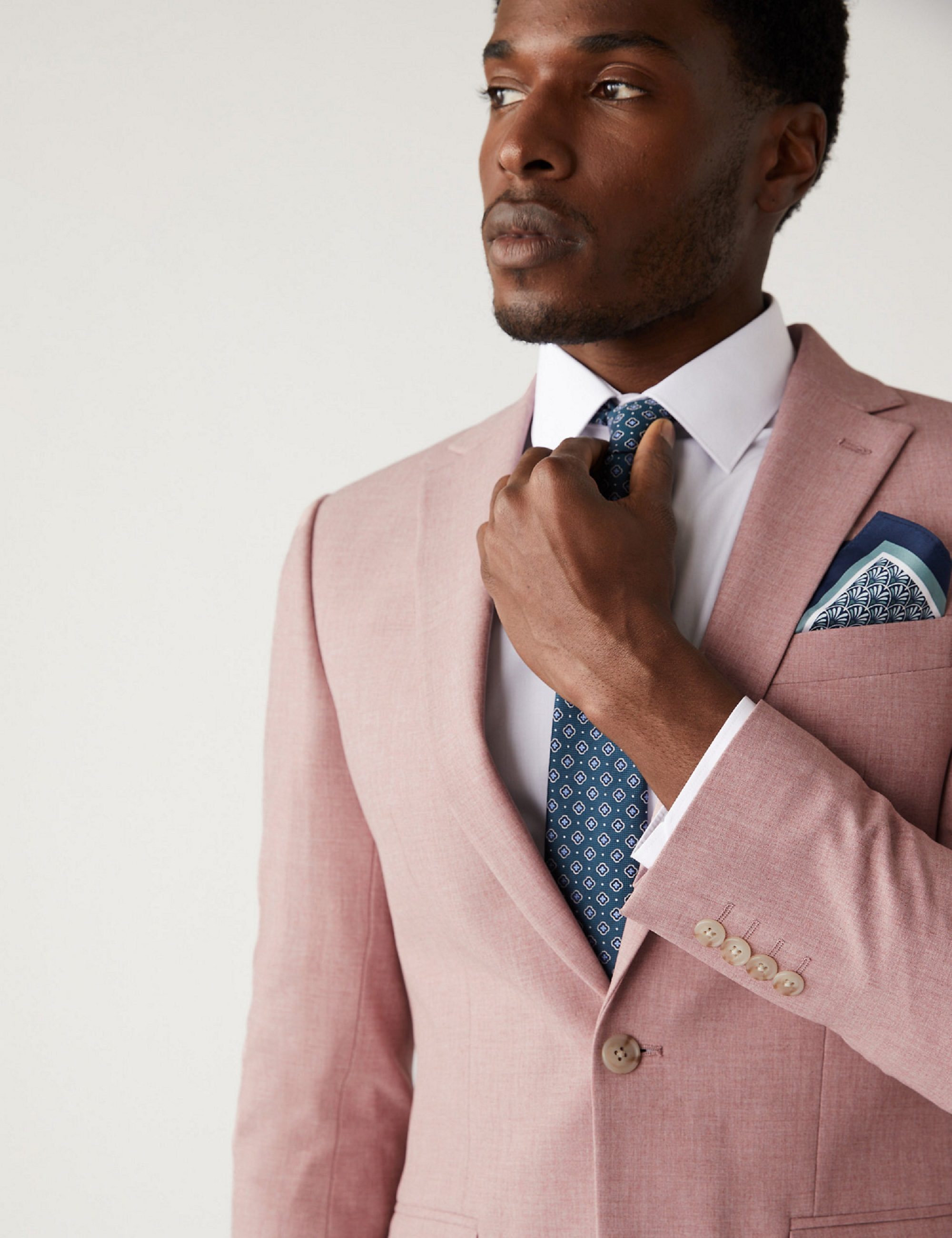 Man in pink blazer with a blue tie and pocket square