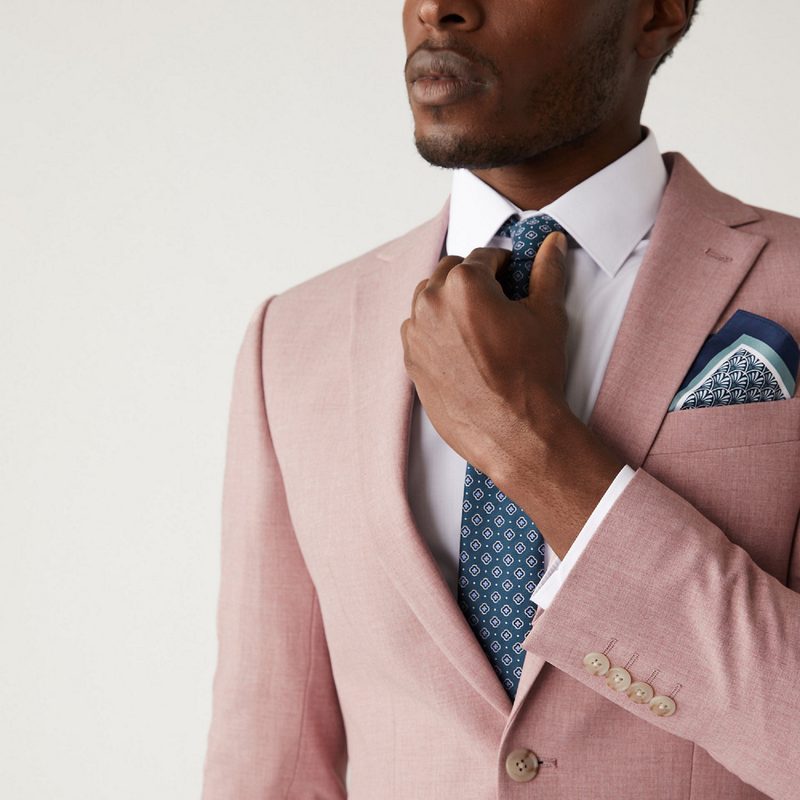 Man in pink blazer with a blue tie and pocket square