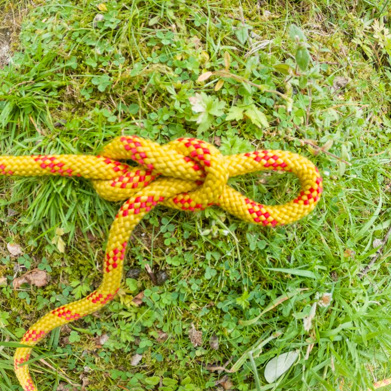 A directional figure-eight is tied in a yellow rope to start a trucker's hitch.