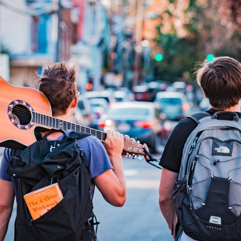 Two people wearing regular backpacks in the city