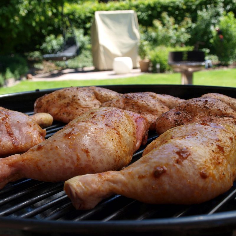 Raw chicken legs on grill