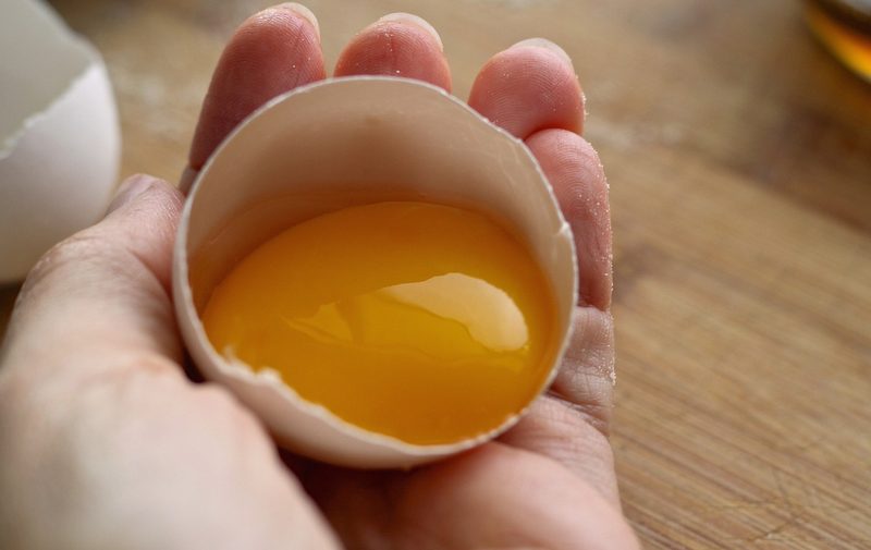 Hand holding cracked egg