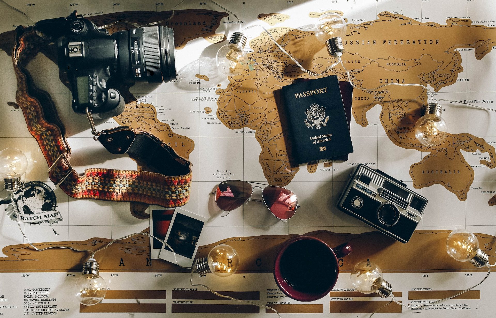 A map laid out with things like a passport, camera, and other accessories on it.