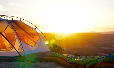 A tent set up as the sun rises.