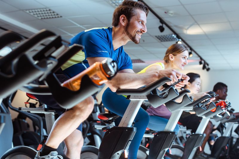 Man on exercise bike with others