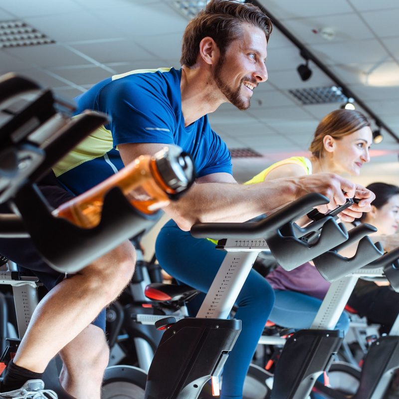 Man on exercise bike with others
