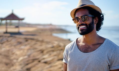 Man with a beard standing on the beach.