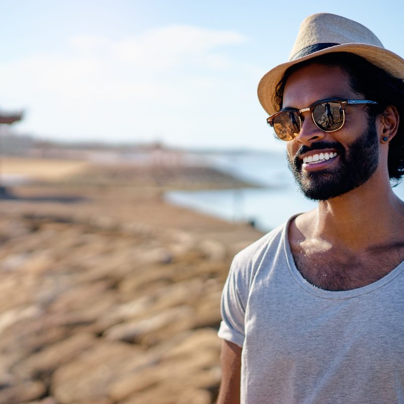 Man with a beard standing on the beach.