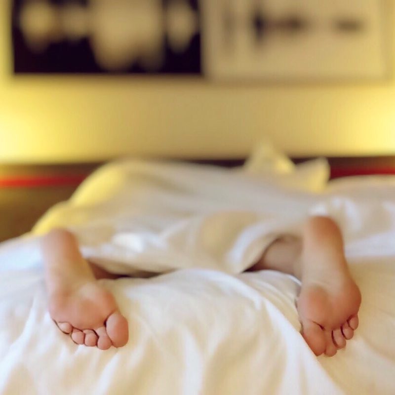 Man sleeping in bed with white sheets