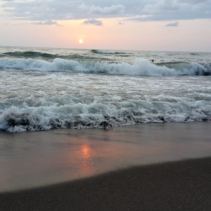 Sunset on a black sand beach along the Black Sea in Ureki, Georgia.
