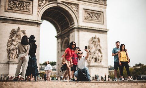 Tourists in France taking pictures in a busy spot.