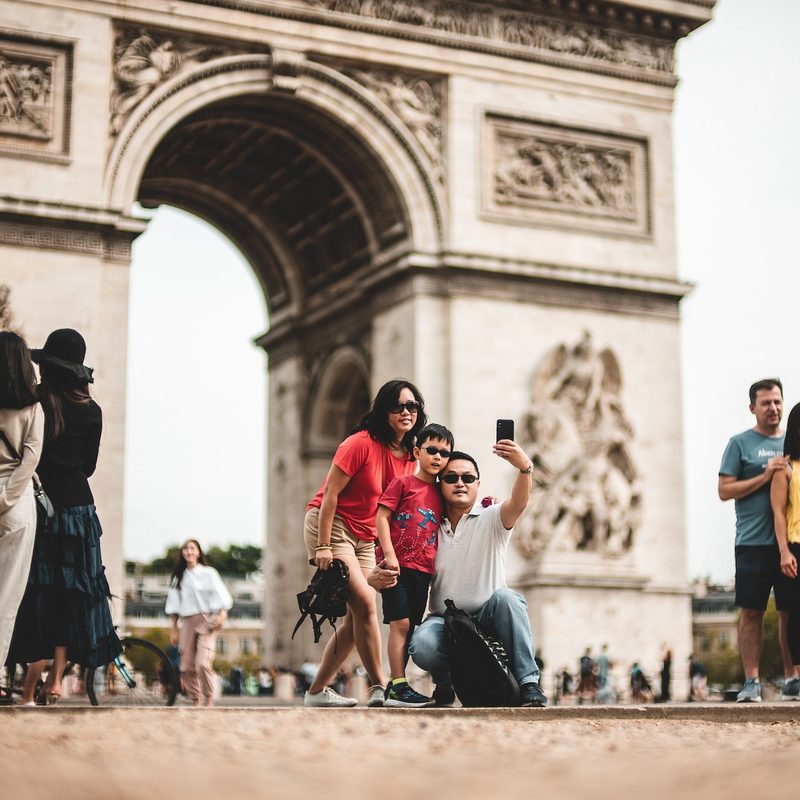 Tourists in France taking pictures in a busy spot.