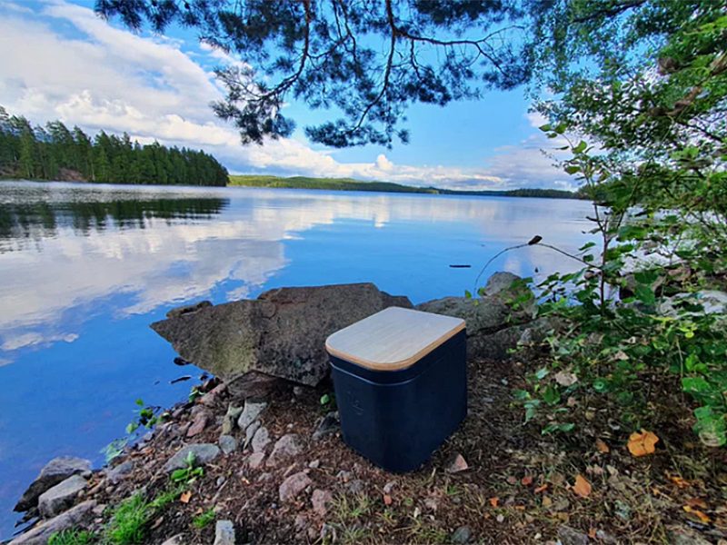 Trelino portable composting toilet staged near a lake.