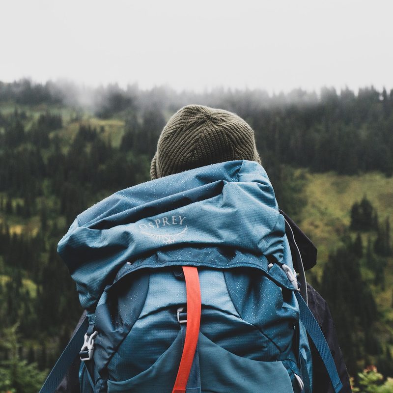 A man wearing a blue backpack while hiking