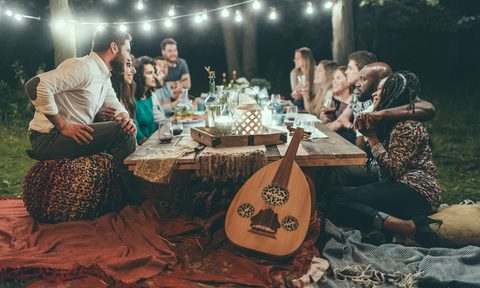 People gathered around outdoor table at night
