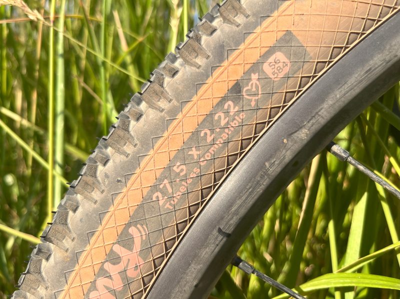 A close up of a tire showing its size to be 27.5 inches