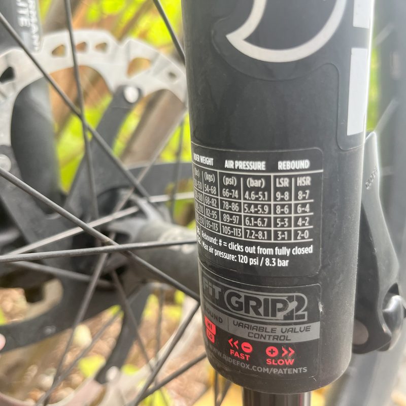 A chart on the lower leg of a mountain bike fork showing how much psi to add to the fork as it corresponds to the riders body weight