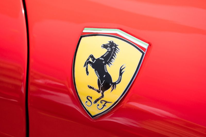 Close-up view of the logo of a Ferrari on public display in a car show