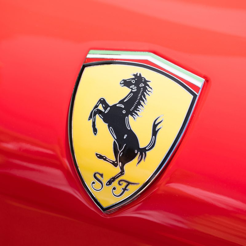 Close-up view of the logo of a Ferrari on public display in a car show