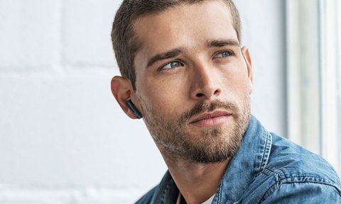 JVC True Wireless Earbuds worn lifestyle image with man in jean jacket.