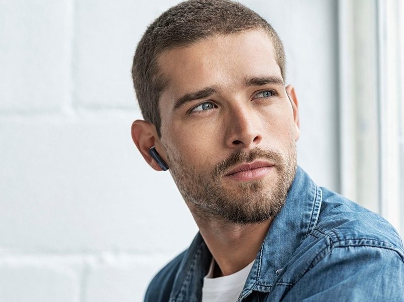 JVC True Wireless Earbuds worn lifestyle image with man in jean jacket.