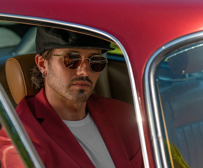Man in round sunglasses sitting in car