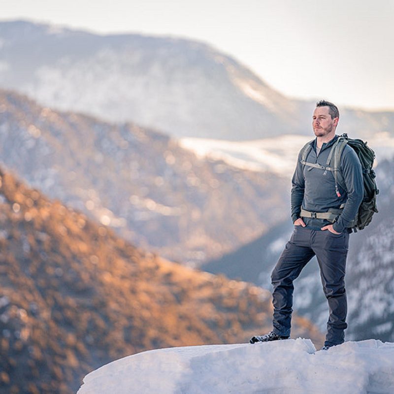 Man at the top of a mountain wearing a Merino wool sweater