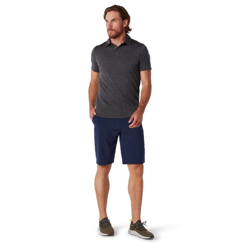 Man wearing a Smartwool polo, shorts, and sneakers