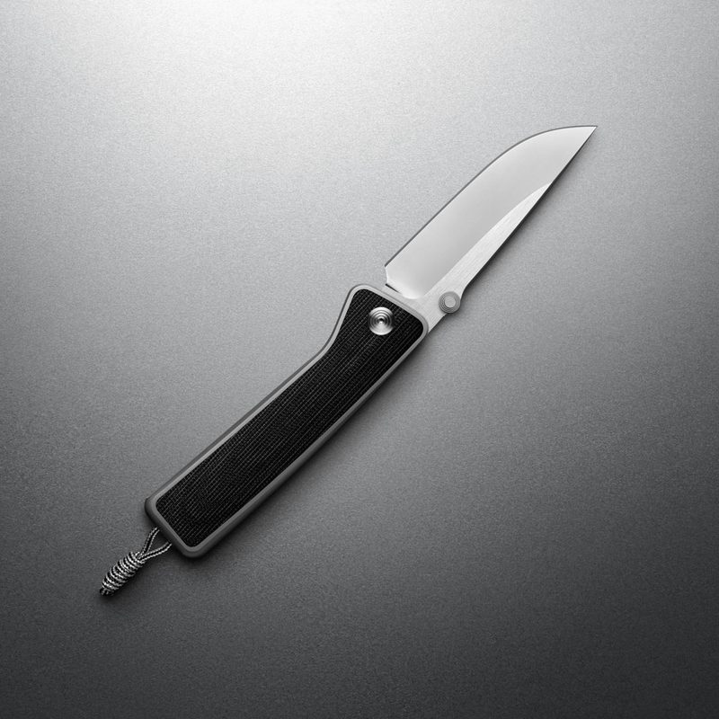 The James Barnes Micarta knife, open on a grey background.