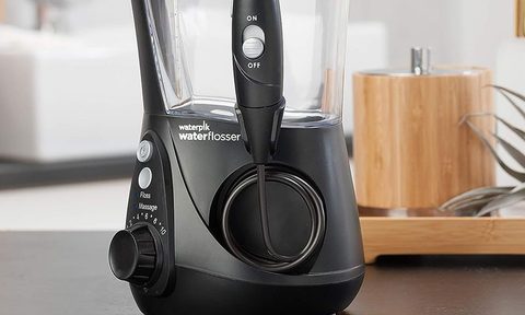 The Waterpik Aquarius Water Flosser on a table side.