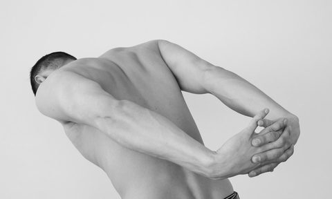 A man stretching his back, shoulders, and chest