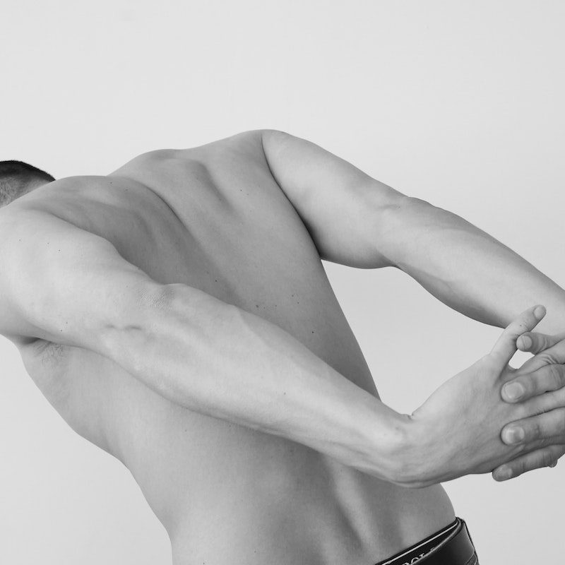 A man stretching his back, shoulders, and chest