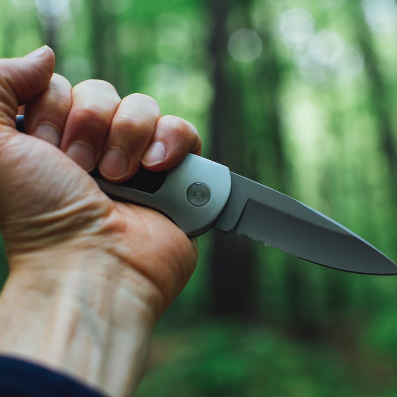 Man holding knife in woods