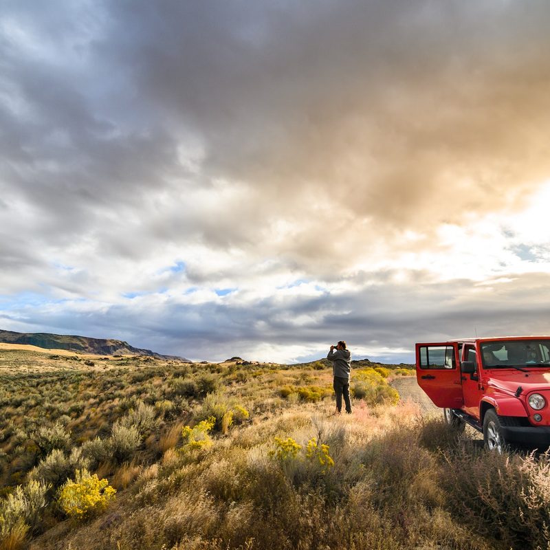 red jeep parked on scenic mountainside