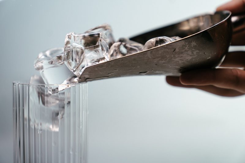 Scoop of ice being poured into glass