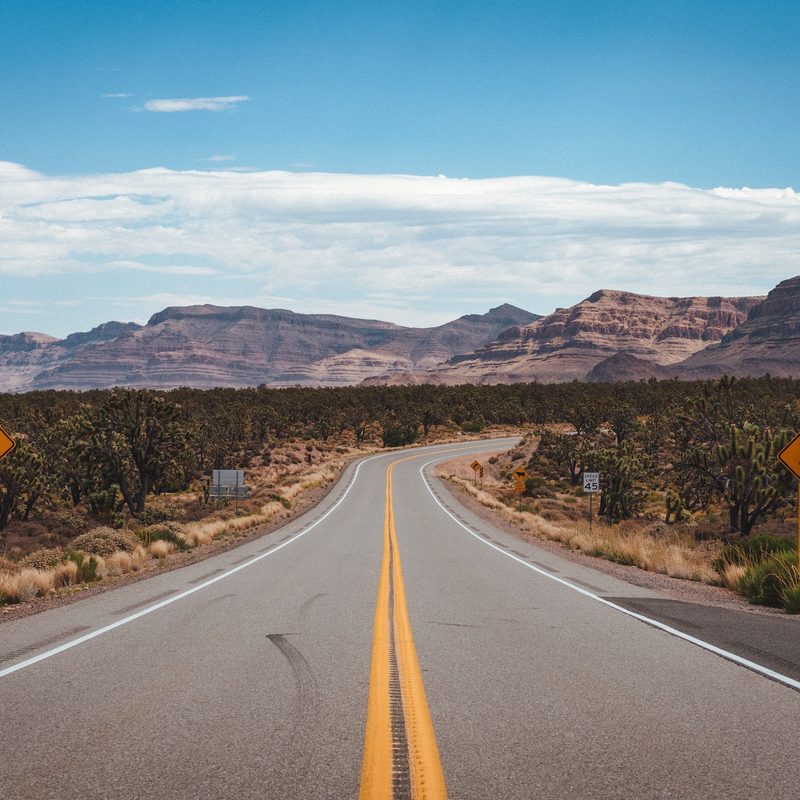 a stretch of highway with mountains in the background