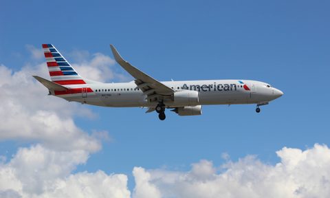 An American Airlines plane in flight in a cloudy sky